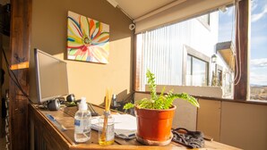 A wooden desk with a potted plant, a bottle of water, and a computer monitor.