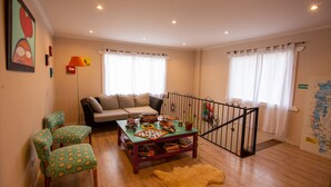 A living room with a sofa, chairs, a coffee table with toys, and a map on the wall.