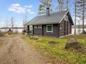 A cabin with a porch, a chimney, and a view of a lake. - Vacation home Varpu by Interhome (Hämeenlinna)