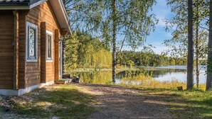 Una cabaña de madera con vistas a un lago y árboles.