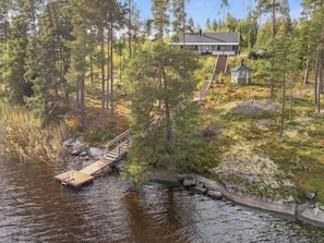 Escape to a serene lakeside retreat with a two-story house and dock.