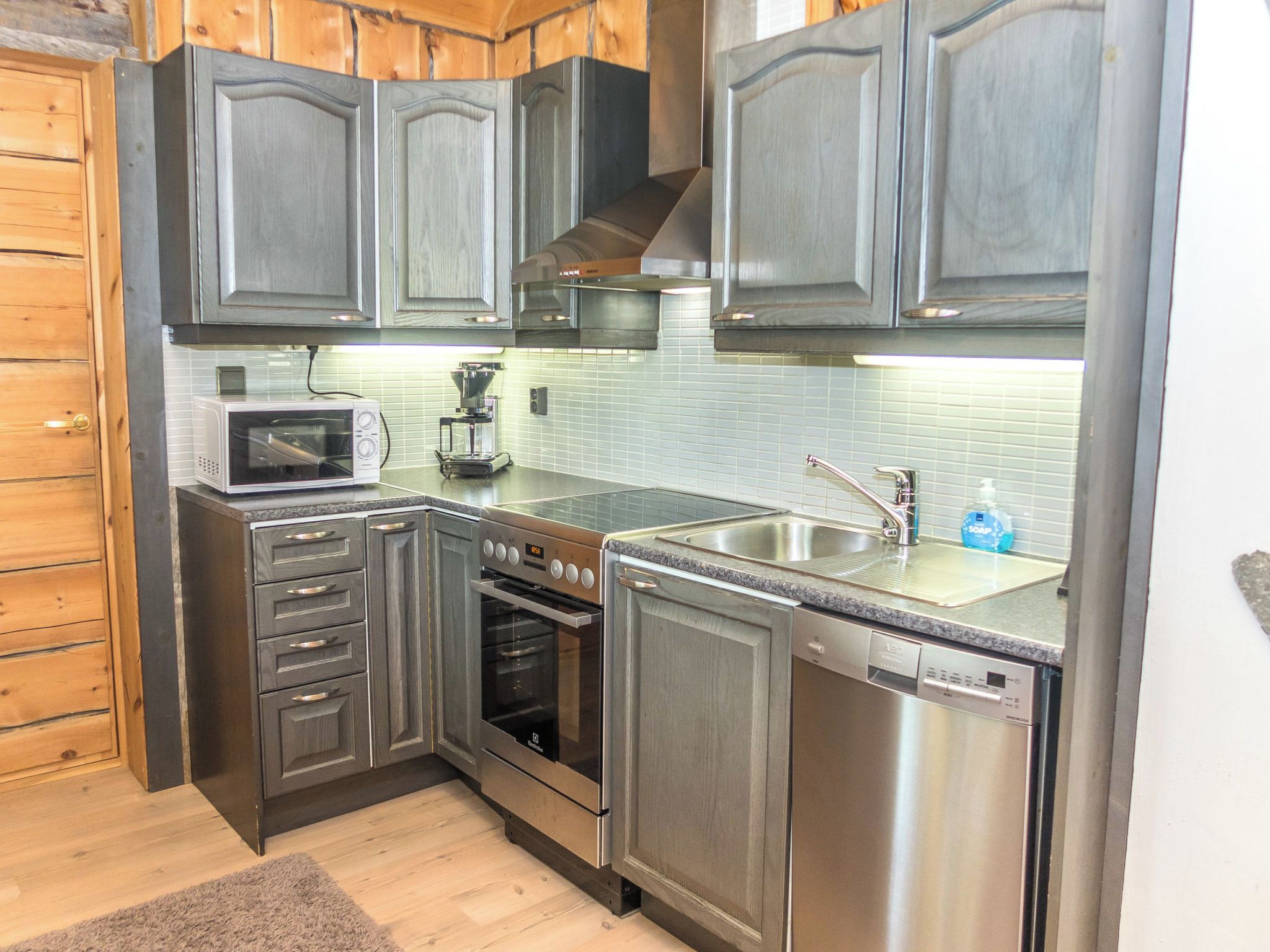 A compact kitchen with a microwave, coffee maker, oven, and dishwasher.