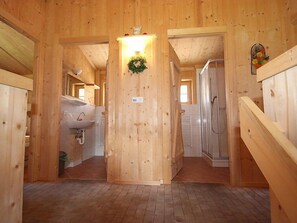 L’intérieur d’une cabane en bois comprend un couloir central qui mène à une salle de bain et à un petit salon.