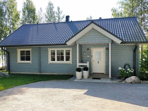 A two-story house with a grey siding exterior, a dark blue tiled roof, and a front porch with a white door. - Sointukallio by Interhome (Savonlinna)