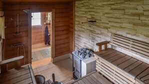 Un cuarto de sauna con bancos de madera, una pared de piedra y suelo de baldosas.
