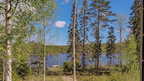 A dirt path leading to a lake surrounded by trees.