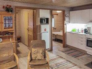 A compact living space with a kitchenette, a dining area, and a seating area with a chair. - Kuusirinne by Interhome (Savonlinna)