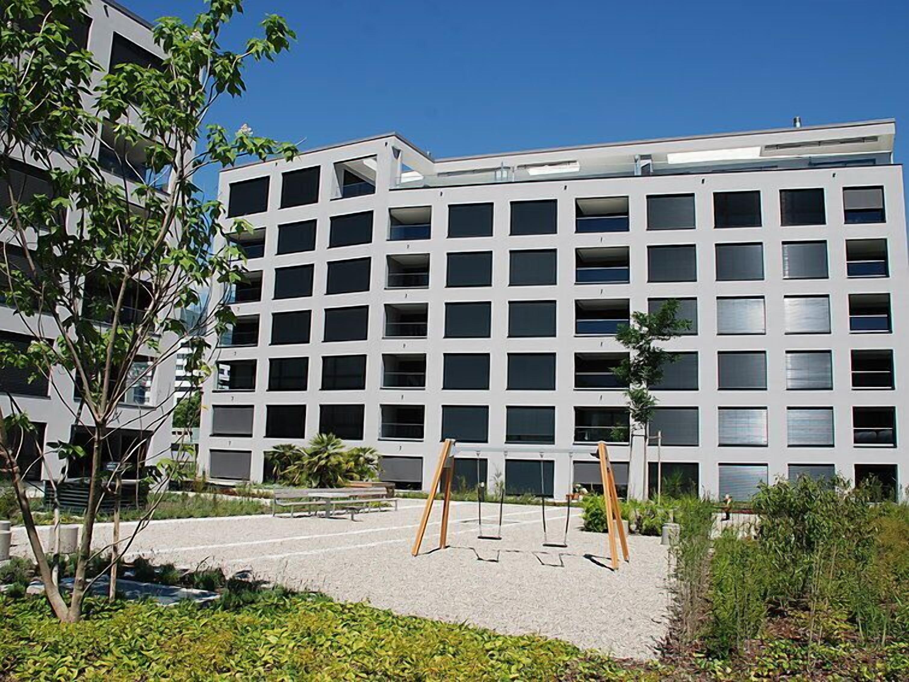 A modern multi-story building with a grid of windows and balconies.