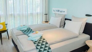 A modern hotel room with a large bed, a small side table, and a chair. - LaVille A-3-4 by Interhome (Locarno)