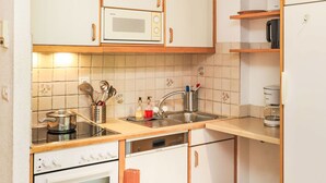 A compact kitchen with a microwave, stove, and sink. - Mont-Fort 51 by Interhome (Siviez-Nendaz)
