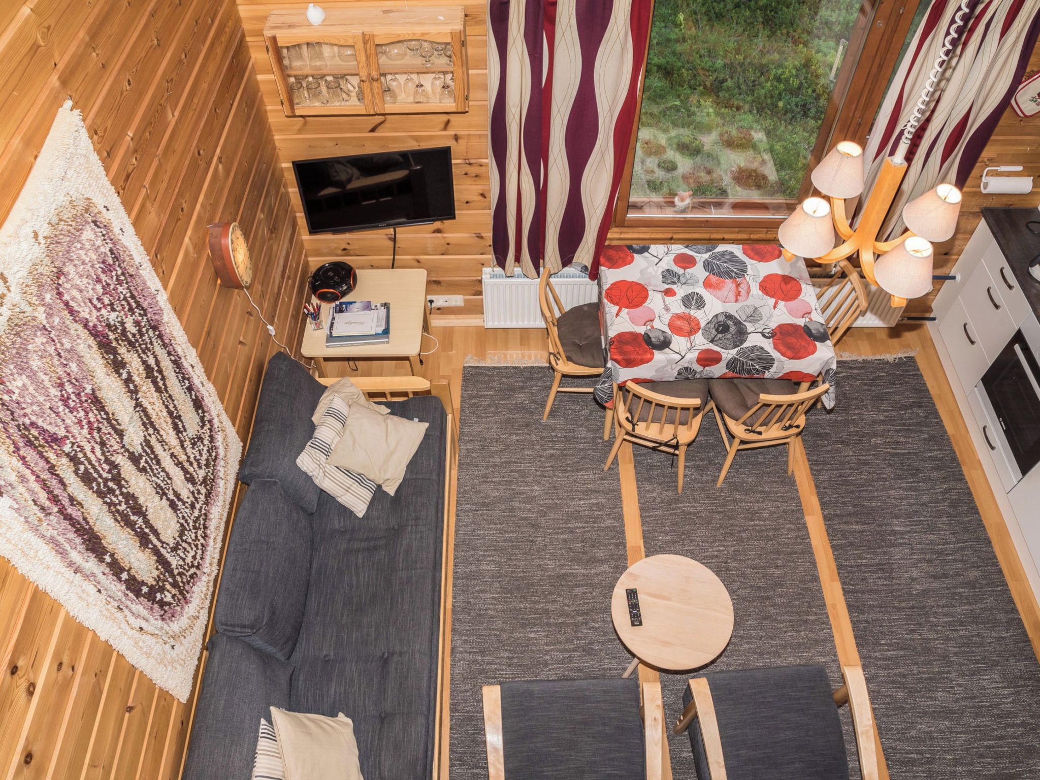 L’intérieur d’un chalet accueillant, avec un canapé, une petite table, un coin repas et un téléviseur.