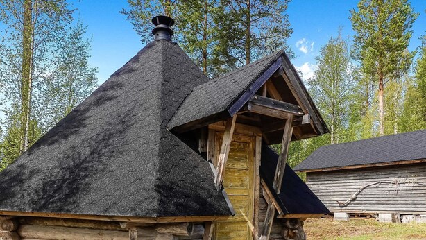 A log cabin with a steeply pitched roof and a wooden door. - Itätullinkievari by Interhome (Salla)