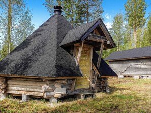 A log cabin with a steeply pitched roof and a wooden door.