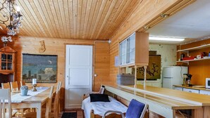 A compact wooden cabin with a dining area, a bed, and a kitchenette. - Itätullinkievari by Interhome (Salla)