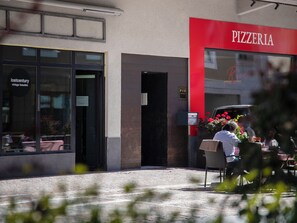 A pizzeria with a red sign, a vintage beauty shop, and a car parked outside. - Chesa Spuonda Verde 1.7 by Interhome (St. Moritz)