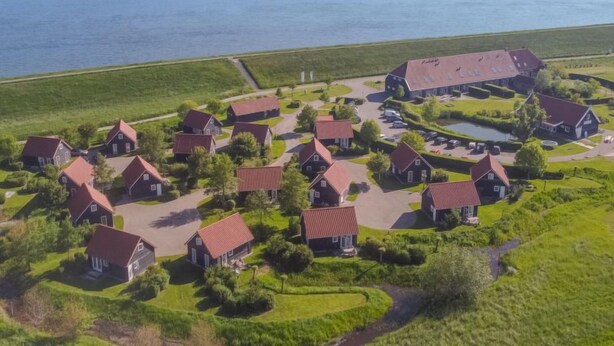 An aerial view of a coastal village with traditional houses, a central building, and a body of water. - Zeeuwse Cottage Wemeldinge by Interhome (Wemeldinge)