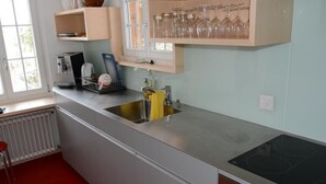 Una cucina moderna con lavello in acciaio inossidabile, forno integrato e finestra sopra il lavello.