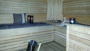 Ein Saunaraum mit einer Bank, einem Handtuch und zwei Wasserflaschen.