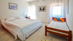A bedroom with two beds, a nightstand, and a framed picture on the wall. - Apartment Andrea by Interhome (Opatija/Bregi)