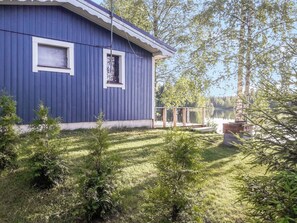 A blue building with two windows, surrounded by a grassy yard and trees. - Rantala by Interhome (Kaavi)