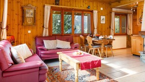 A cozy wooden cabin interior with a dining area, a sofa, and a table with a red tablecloth. - Als man zählte 1989 by Interhome (St Niklaus)