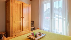 A room with a bed, a wooden wardrobe, a chair, and a window with curtains. - Oyan Aldo by Interhome (Mimizan)