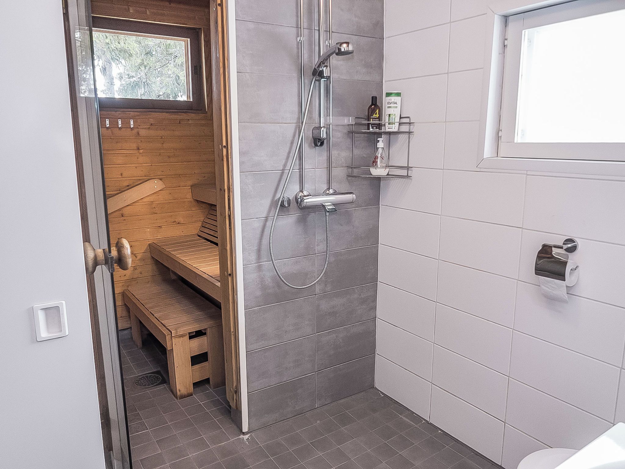 A bathroom with a shower, a toilet, and a bench.
