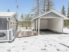 A cabin with a covered porch and a deck, surrounded by snow and trees. - Kuusela by Interhome (Kuusamo)