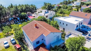 Et boligområde med huse, en swimmingpool og en sø i baggrunden.