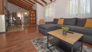 Un salon avec un canapé, une table basse et une cuisine en arrière-plan.