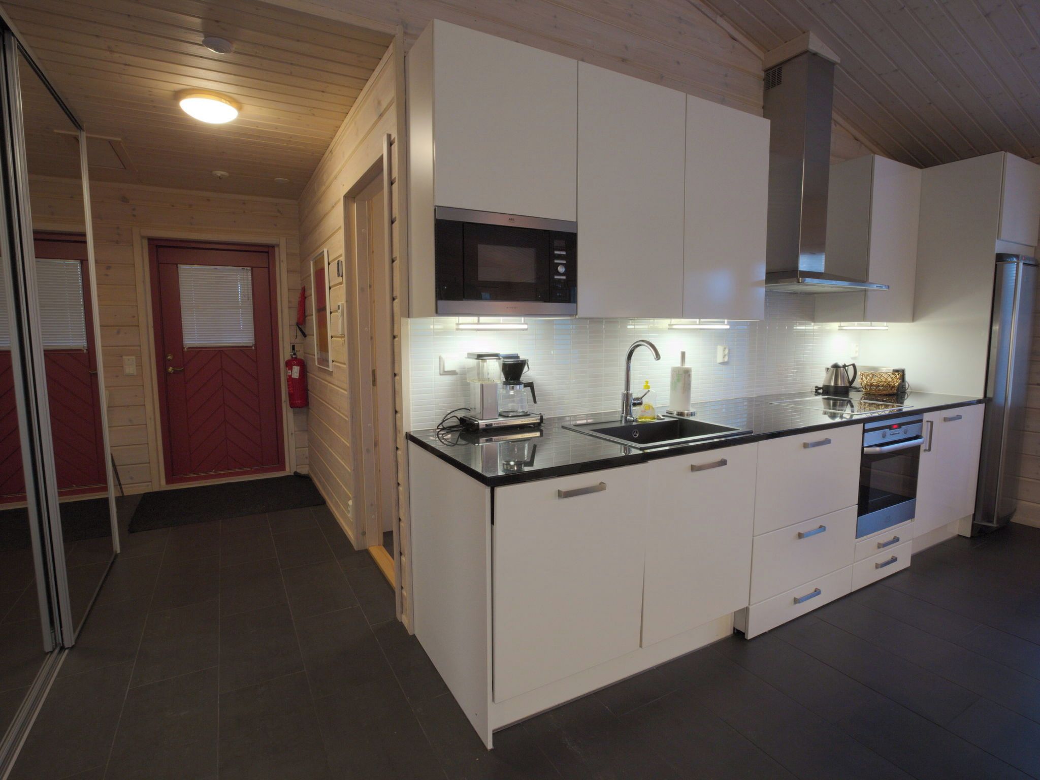A modern kitchen with white cabinetry, a microwave, a coffee maker, and a built-in oven.