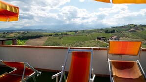 A terrace with outdoor seating and a view of vineyards. - Vacation home Breda by Interhome (Città Sant'Angelo)