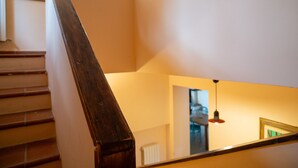 A wooden staircase with a handrail, leading to a room with a ceiling light and a framed picture on the wall. - Vacation home Breda by Interhome (Città Sant'Angelo)