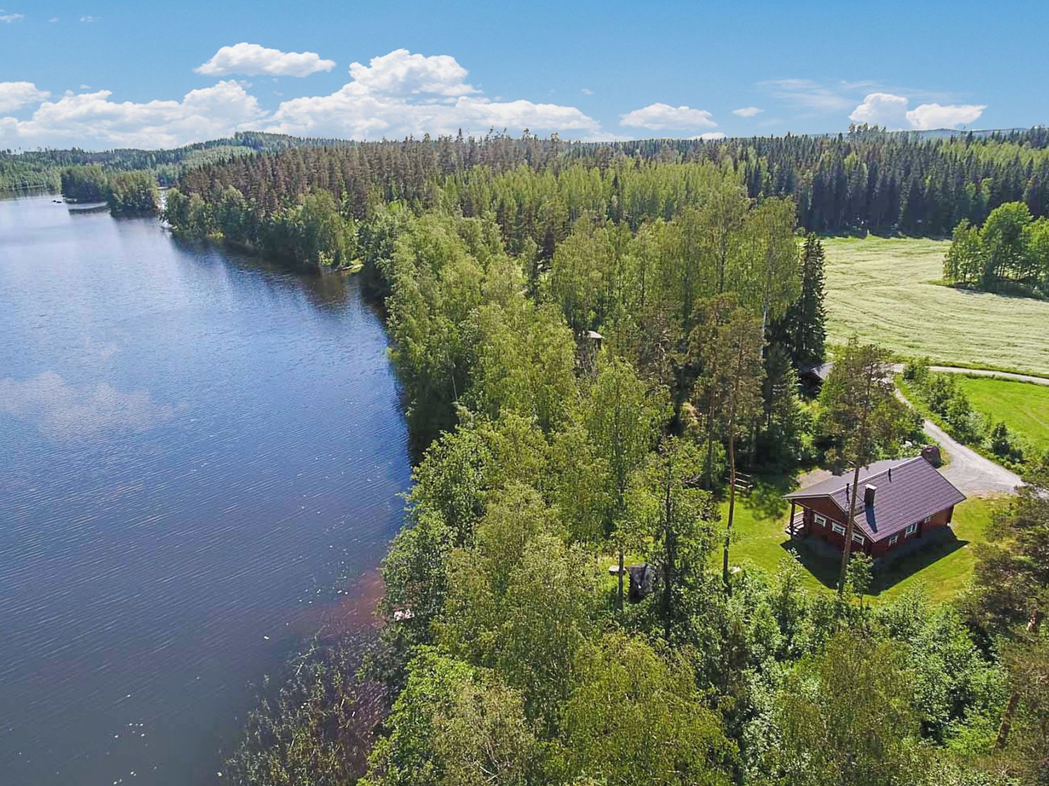Una cabaña junto al lago con vistas al lago y al bosque.