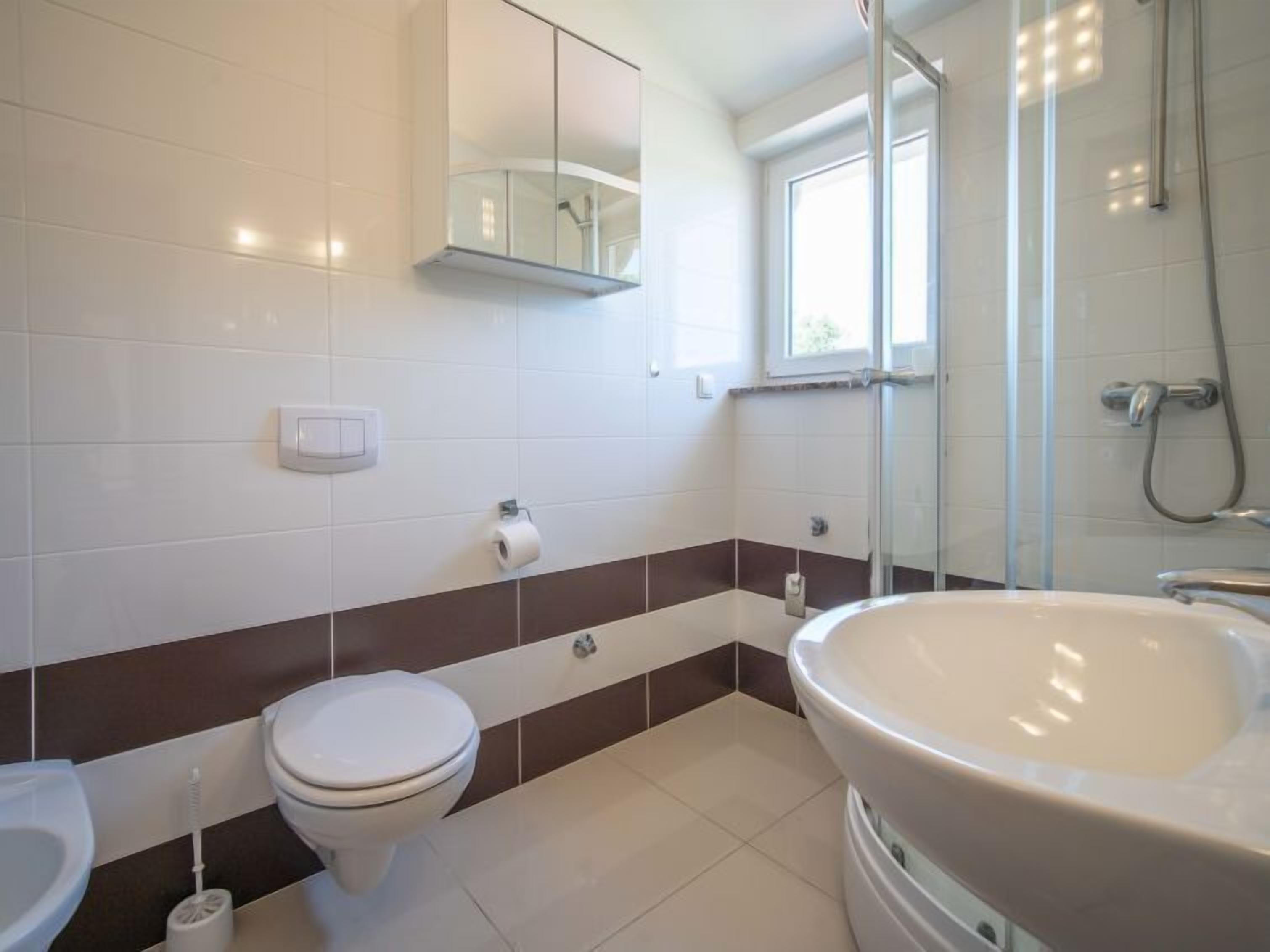 A modern bathroom with a toilet, bidet, and bathtub.