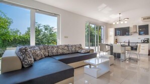 A modern living room with a sectional sofa, a dining area, and a kitchen. - Graziani by Interhome (Krk/Kornic)
