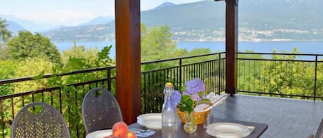 A table set for two with a view of a lake and mountains.