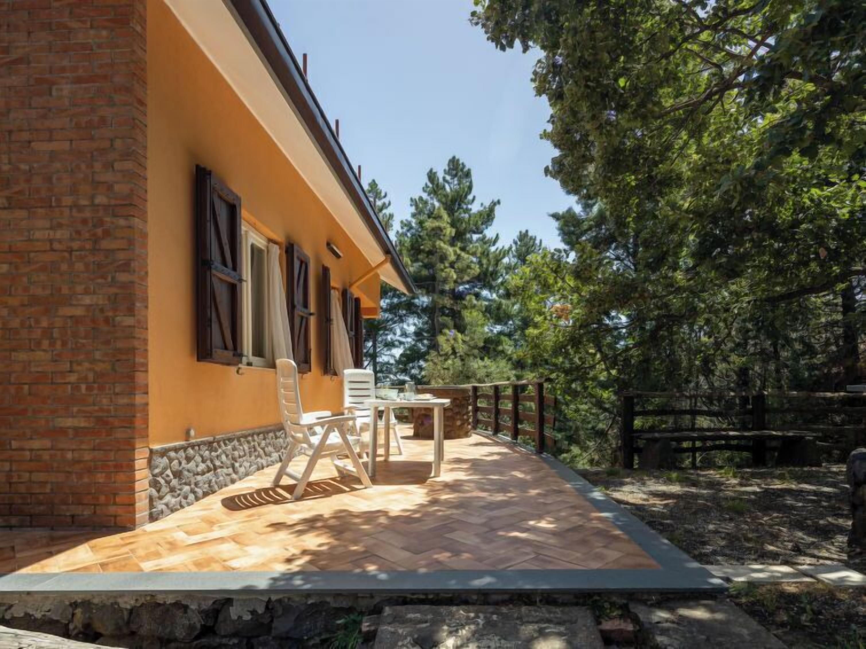 A patio with outdoor furniture, a stone wall, and a wooden fence.
