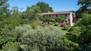 A stone house with a tiled roof, surrounded by lush greenery and trees. - La Forra by Interhome (Vicchio)
