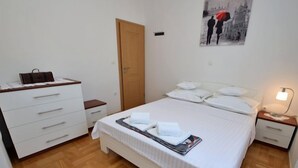 A neatly arranged bedroom with a bed, bedside tables, a dresser, and a wall-mounted picture. - Bili dvori by Interhome (Trilj)