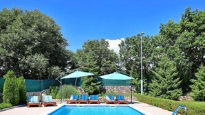 A rectangular swimming pool with a metal ladder on one side, surrounded by lounge chairs and umbrellas. - Bili dvori by Interhome (Trilj)