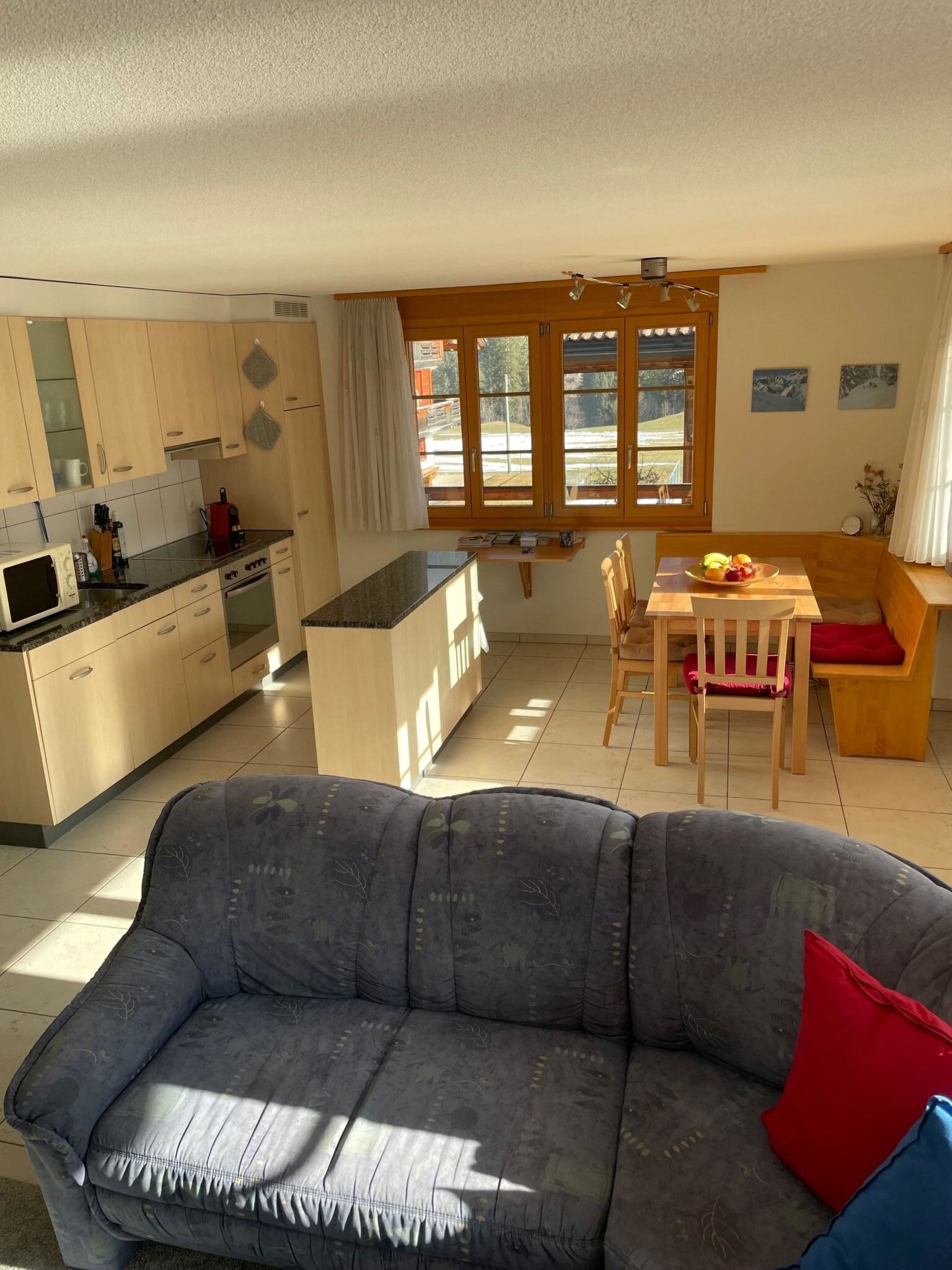 A modern kitchen with wooden cabinets and a built-in microwave.