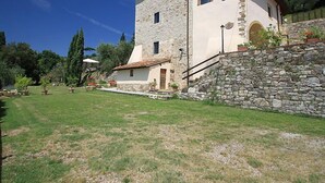 A stone building with a tiled roof, a stone staircase, and a well-maintained lawn. - Villa Monteloro by Interhome (Florence)
