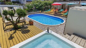 A swimming pool with a hot tub, wooden deck, and lounge chairs. - Apartment Nika by Interhome (Umag)