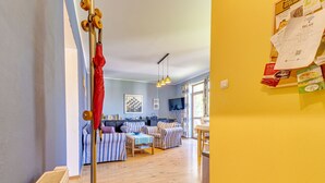 Un salon chaleureux avec des canapés à rayures, un plancher en bois et un coin repas comprenant une table et des chaises.
