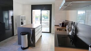 Una cocina moderna con una isla central, electrodomésticos integrados y un amplio ventanal.