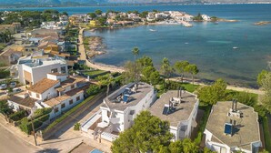 An aerial view of a coastal town with buildings, a beach, and a marina. - Es Clot by Interhome (Alcúdia)