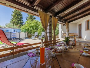 Enjoy al fresco dining in this charming outdoor space, complete with tables, chairs, and a refreshing beverage station.