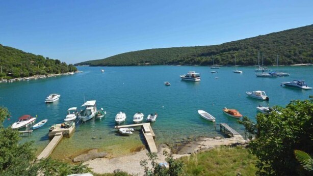 A marina with boats docked, surrounded by hills and clear blue water. - Vacation home Bakić by Interhome (Pula/Krnica)