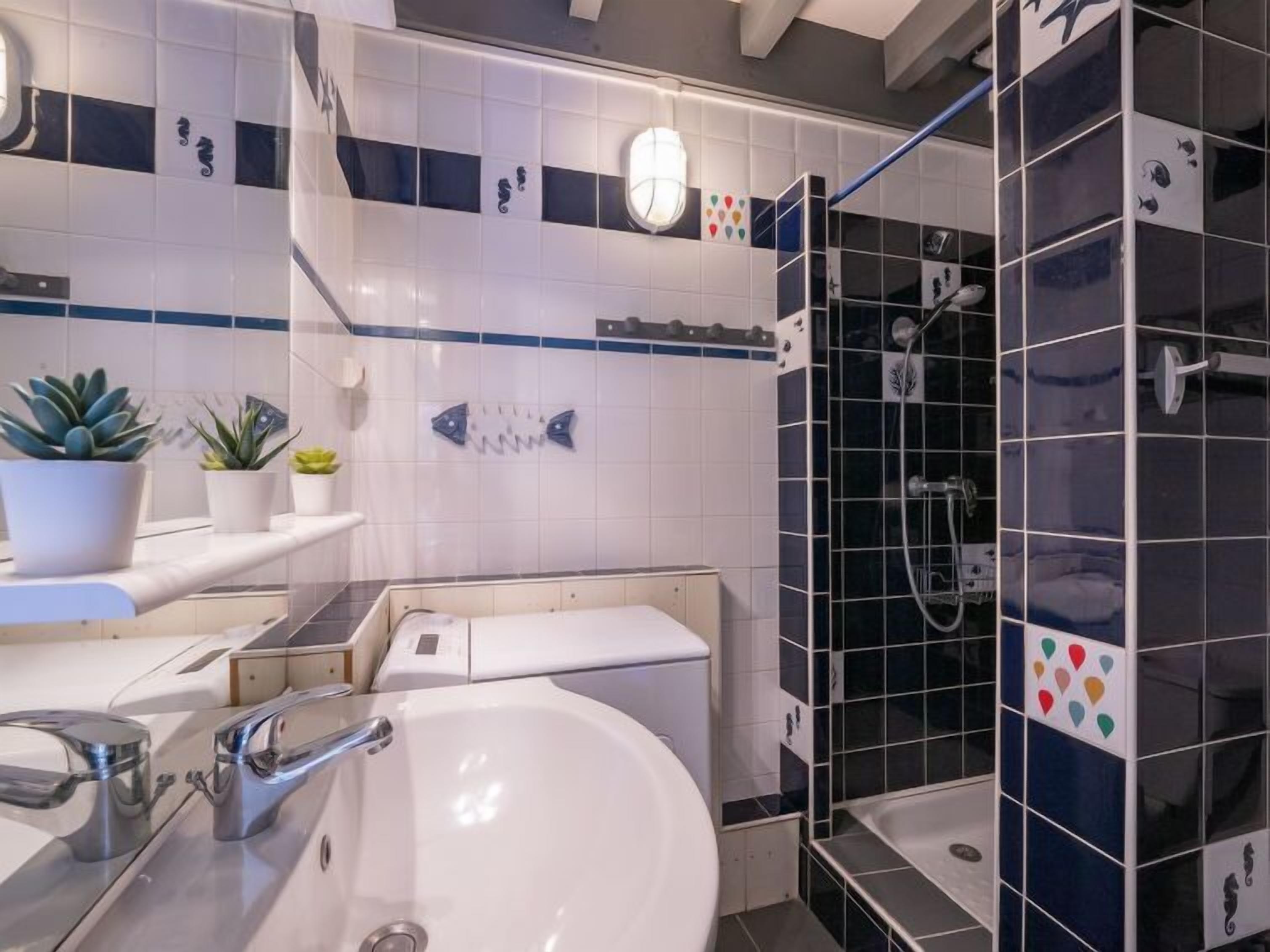 A modern bathroom with a white sink, a bathtub, and a shower area.